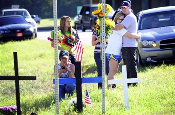 At the intersection of Bobby Jones Expressway and Gordon Highway, friends pause at a makeshift memorial to Augusta-Richmond County Sheriff's Deputy James D. Paugh who was slain at this site on Oct. 23 in Augusta, Ga. A National Guardsman who appeared to be drunk and firing gunshots at passing cars shot and killed Paugh, then committed suicide on the Georgia road, authorities said Sunday. 